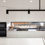 white kitchen with drop lights and breakfast bar