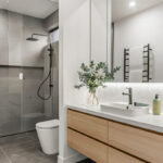 bathroom with walk in shower, white and grey